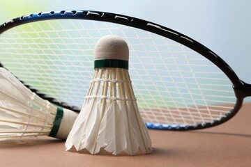 Feather badminton shuttlecocks and racket on court, closeup