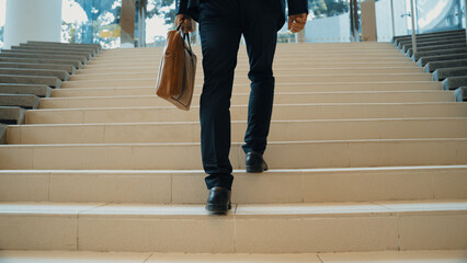 Closeup of business man leg go up the stairs. Successful man going up the stairs while explore a...