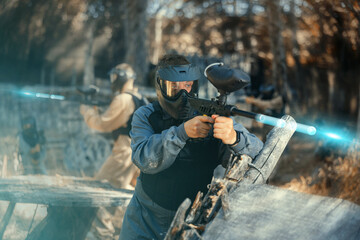 Man aiming with paintball market on battleground. Competitive shooting sport.