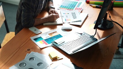 Close up of smart business man hand choosing color palettes while sitting at meeting table with...