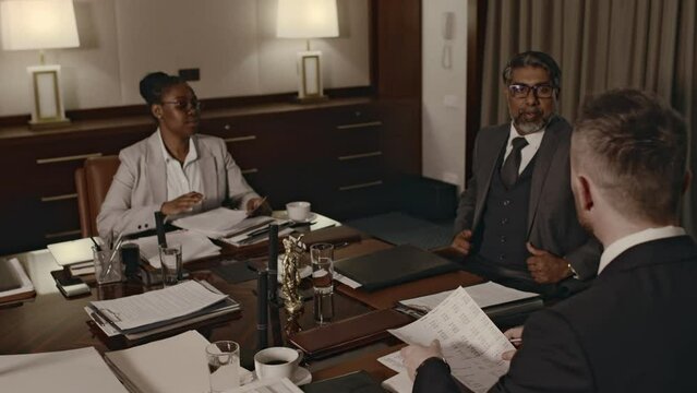 Tracking footage of lawyers office CEO arriving at conference with attorneys to discuss evidence on criminal or civil case and analyze documents in boardroom
