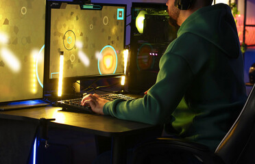 Man playing video games on computer at table indoors