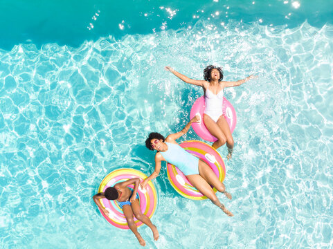 Biracial couple enjoys a sunny day in the pool, with copy space