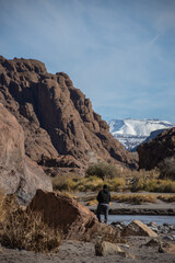 Man looking towards mountains and river.