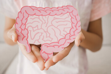 Preteen girl hands holding intestine shape, healthy bowel digestion, leaky gut, probiotic and...