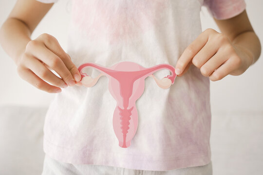 Preteen girl hands holding uterus, teen health, PCOS, first period concept