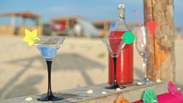 Man places half-drunk ale on bar in middle of beach leaving drinks for later to stretch pleasure. Summer drinking fun on beach on vacation