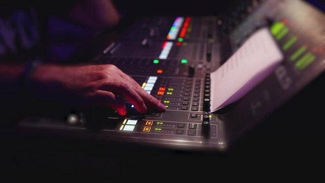 View of lighting technician operator working on mixing console workplace during live event concert on stage show broadcast, light mixer controller panel, sound technician with professional equipment