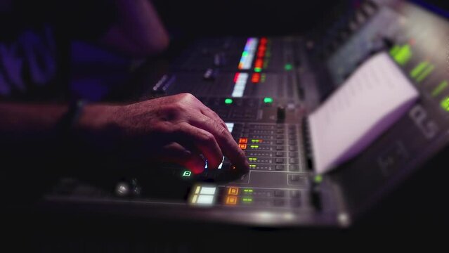 View of lighting technician operator working on mixing console workplace during live event concert on stage show broadcast, light mixer controller panel, sound technician with professional equipment