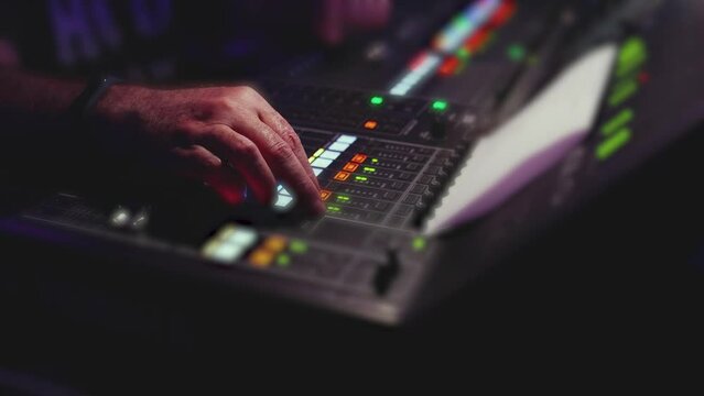 View of lighting technician operator working on mixing console workplace during live event concert on stage show broadcast, light mixer controller panel, sound technician with professional equipment