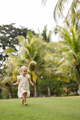 Happy cute little girl running on the grass in the park. Happiness., childhood