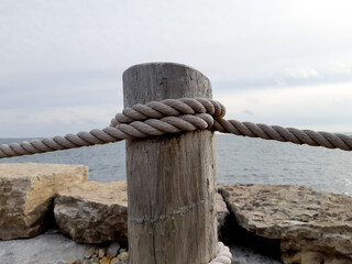 a wooden post with heavy rope to act as a waterside guard rail