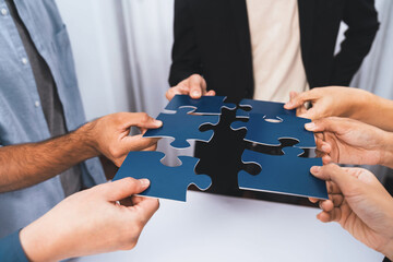 Business team joining jigsaw puzzle together symbolize group of business partnership and strong...