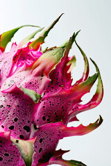 Obraz premium Striking close-up of a dragon fruit, emphasizing its vibrant pink skin with green accents, set against a white background.