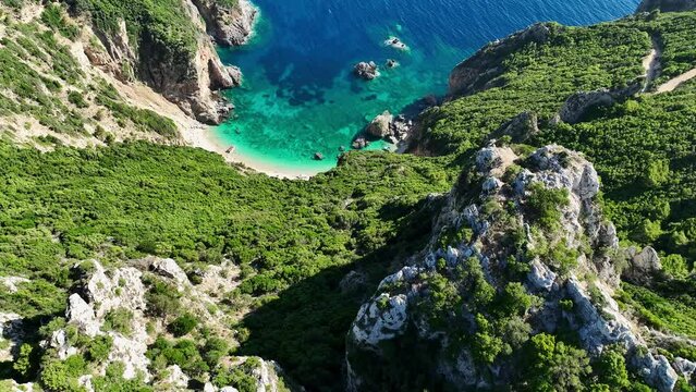 Aerial shot of Giali Beach in Corfu, lush greenery surrounding turquoise waters, sunny day