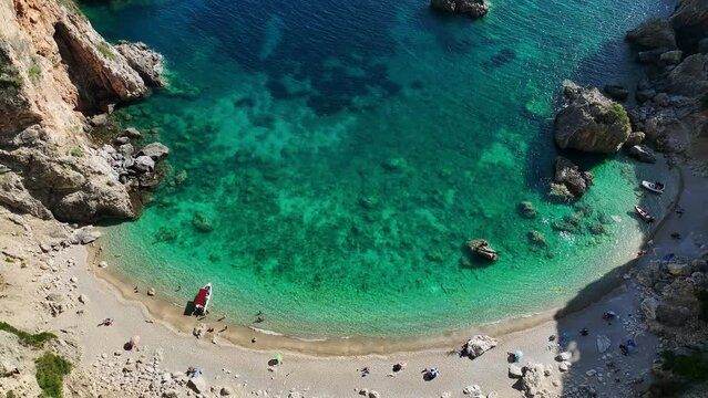 Giali beach in corfu with crystal-clear turquoise waters and sunbathers on sand, aerial view