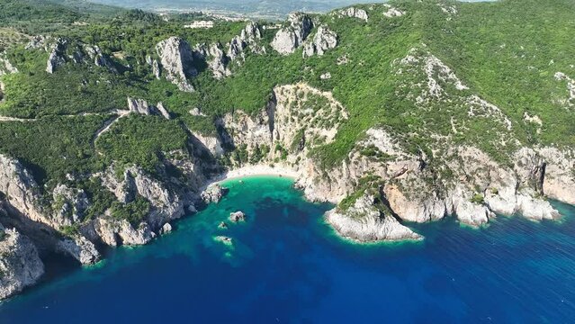 Aerial shot of Giali Beach on Corfu Island, Greece with clear turquoise waters and rugged cliffs, sunny day