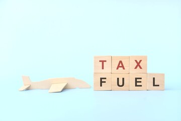 Aviation fuel tax concept. Wooden blocks typography on blue background.