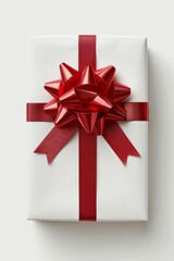 A red ribbon adorns the white present against a white backdrop.