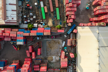 Cebu CIty, Philippines - A busy day at the Port of Cebu, featuring colorful red shipping containers neatly stacked, industrial vehicles, and warehouses.