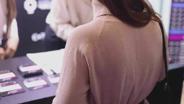 Process of checking in on a conference congress forum event, registration desk table, visitors and attendees receiving a name badge and entrance wristband bracelet and register electronic ticket
