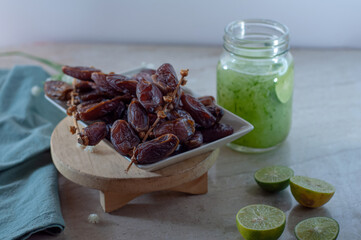 lime water and dates fruit lay on marble table.