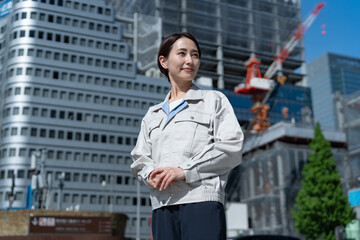 工事中のビルの前に立つ日本人女性