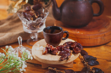 a cup of tea with date fruits lay on wooden table. It' the best dish for breaking fast during...