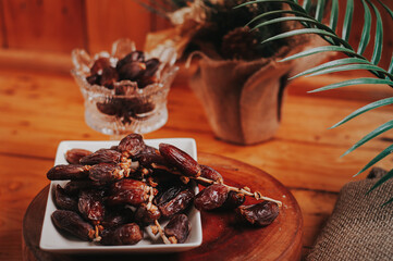 a cup of tea with date fruits lay on wooden table. It' the best dish for breaking fast during ramadan