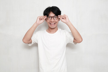 Smiling Asian young man in glasses looking at the camera