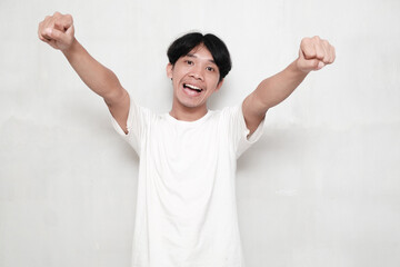 Asian man is pointing into the camera with an excited facial expression.
