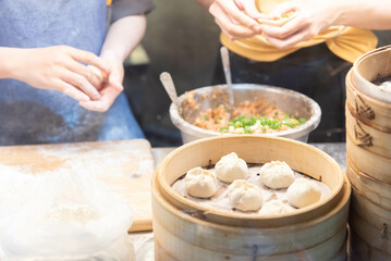 Mother teaching daughter to make Xiao Long Bao Local food of Asian countries Family food, street food, steamed Chinese food