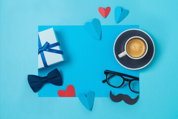 Happy Fathers day creative concept with coffee cup,  heart shape and gift box on blue background. Top view, flat lay