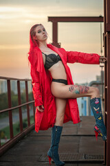 Portrait of a young beautiful red-haired girl outdoors in revealing clothes.