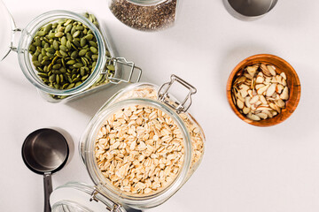 Oatmeal, chia and pumpkin seeds in a glass jars, ingredients for granola or overnight oats