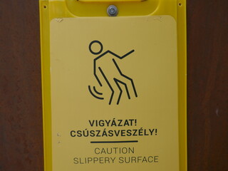 Caution slippery surface sign with English and Hungarian Vigyázat, csúszós felület