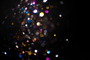Fototapeta na wymiar Colorful falling glitter sequin confetti on black background