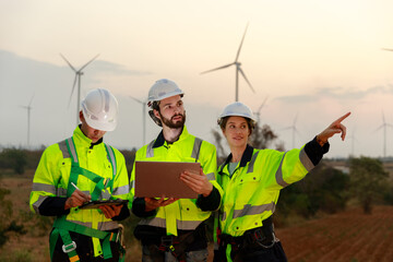 Engineer wearing safety uniform using tablet discussed plan about renewable energy at station...