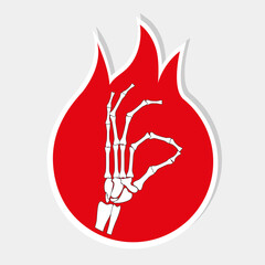 The sticker of the skeleton's hand makes an Ok  sign on the background of the flame.