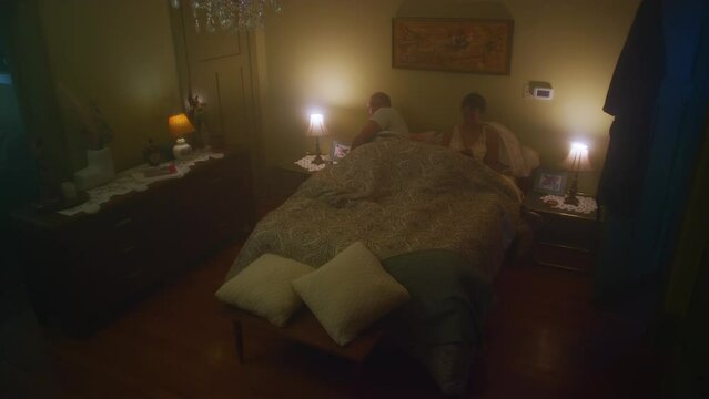 Man gets in bed with wife.