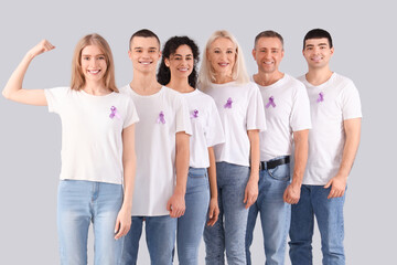 Fototapeta premium People with lavender awareness ribbons on light background. World Cancer Day