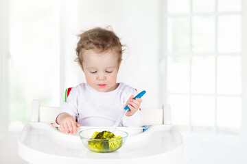 Baby eating vegetables. Solid food for infant.