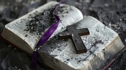 Ash Wednesday concept. Cross and a purple ribbon on top of an open bible covered with ashes. 