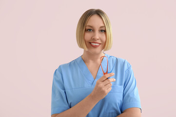 Female dentist with tongue scrapers on pink background