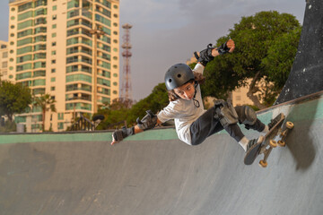 Boy riding his skateboard without fear wearing protection at the skate park