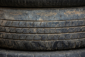 Stacked tires beside a car tire