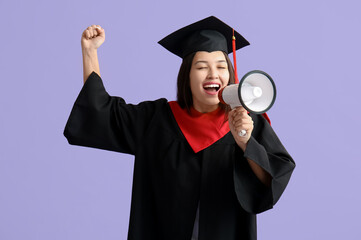 Young female graduate with megaphone on lilac background
