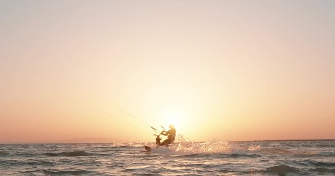 Kite surfers riding kite surf at sunset. Kitesurfing silhouette view. Extreme watersport activity