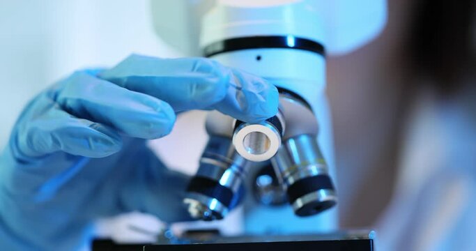 Scientist uses a microscope to study a sample in a laboratory