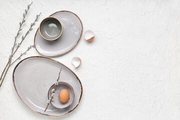 Stylish table setting with Easter eggs and willow branches on white background